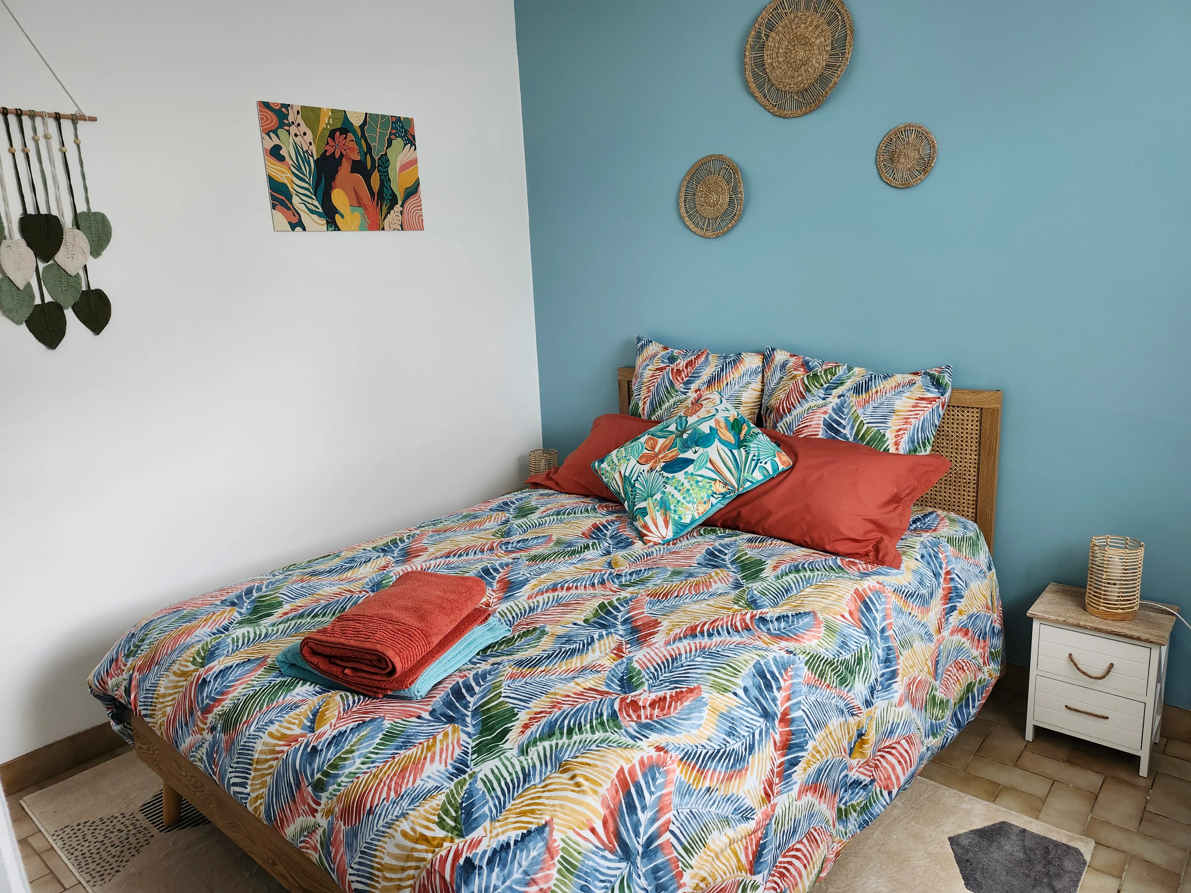 Chambre Bleu lagon du gîte de Mellonia : mur bleu clair, paniers tressés et lit double