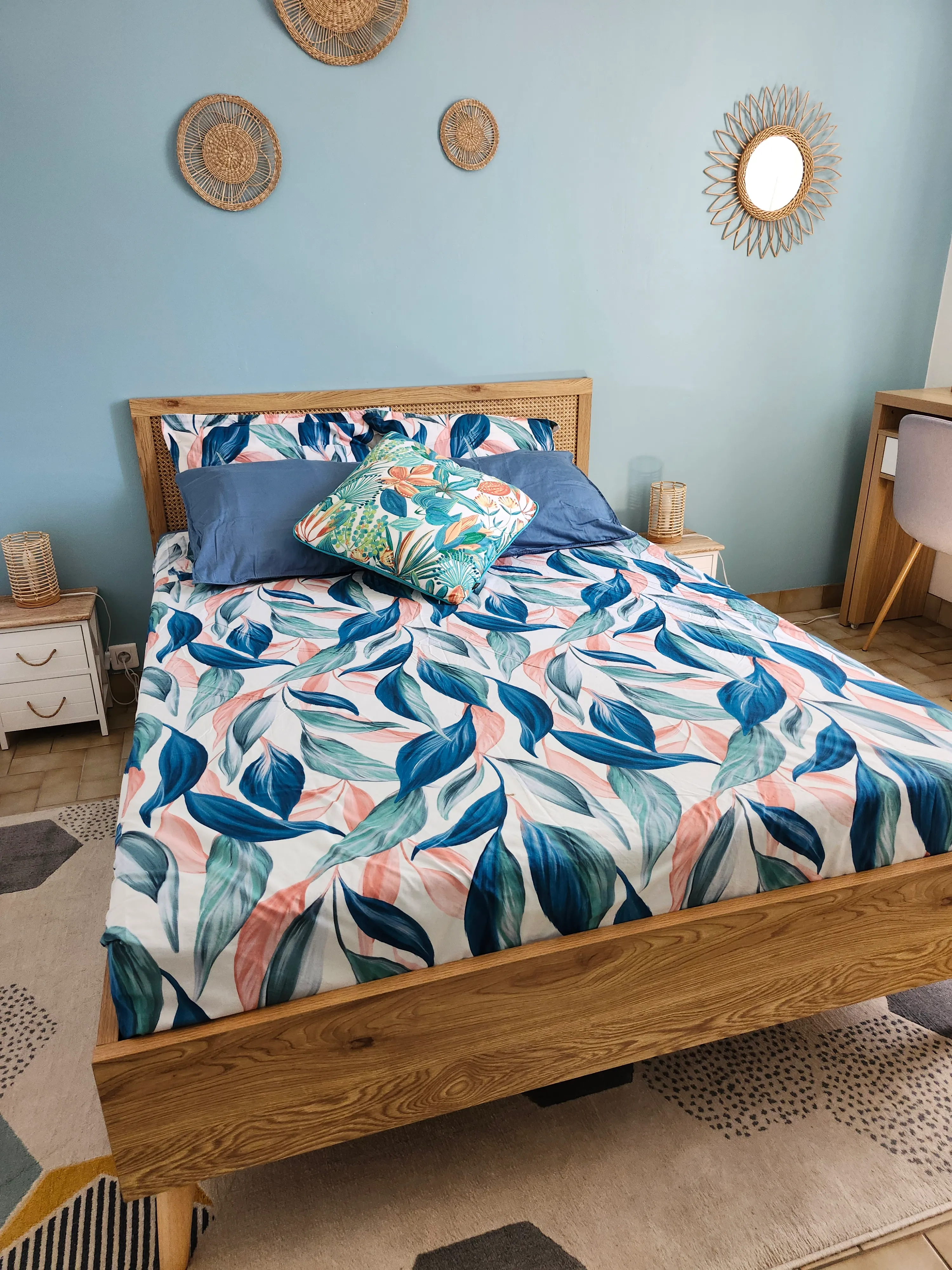 Chambre Bleu lagon : lit double, parure à feuillages et miroir soleil