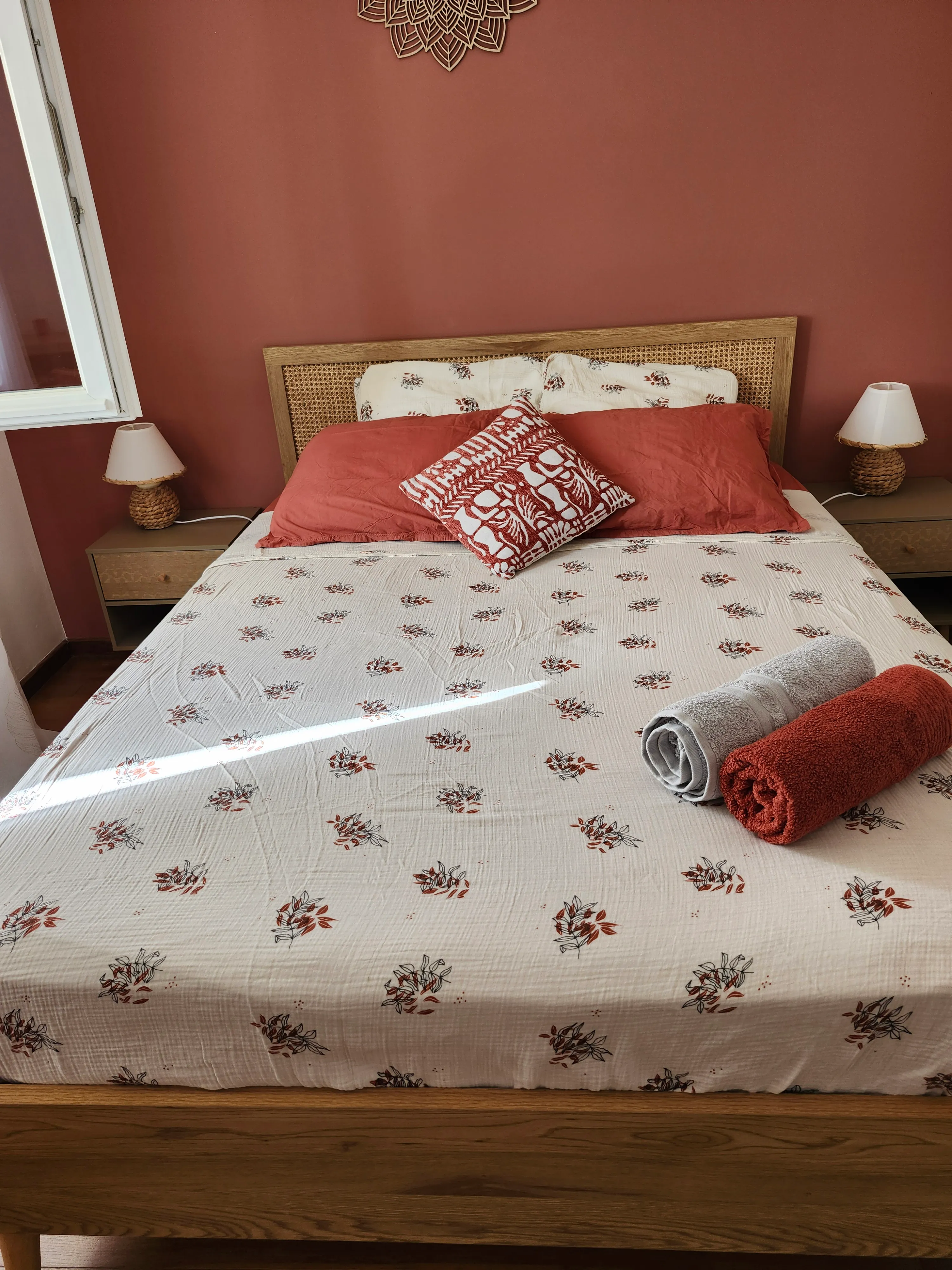 Chambre Terracotta : lit double, coussins terracotta et lampes en corde